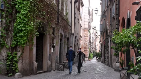 Rome Apt 7th 2020: Boy and girl with masks walk in the streets of Rome Stock Footage 135359316