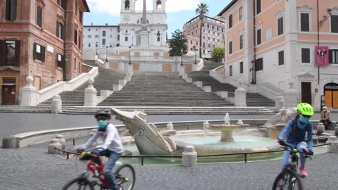 Rome Apt 7th 2020, Two young boys with bike in deserted square due to covid-19 Stock Footage 135359363