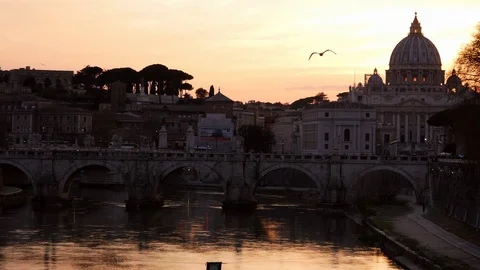 Rome, dramatic orange sunset behind the Vatican Dome. A bird flies from far Stock Footage 104967930