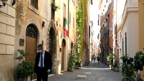 Rome, May 1st 2020: Man with mask and gloves in deserted streets due to lockdown Stock Footage 148792545