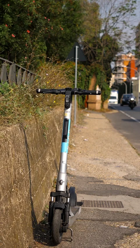 Rome, October 2, 2025: Shared electric scooter parked on sidewalk Stock Footage 335695589