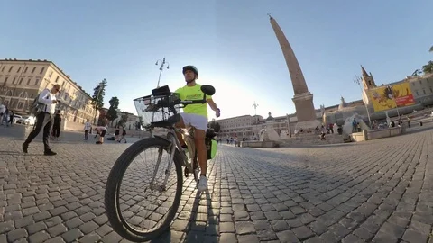 Rome, Piazza del Popolo, a man rides by bike at sunset, people walking Stock Footage 112876483