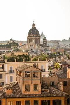 Rome rooftops and dome in warm golden light Фото