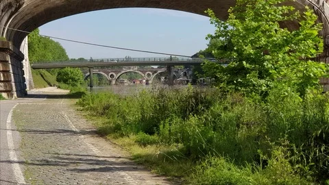 Rome, shooting in motion along the Tiber river with ancient bridge and houseboat Stock Footage 108586077