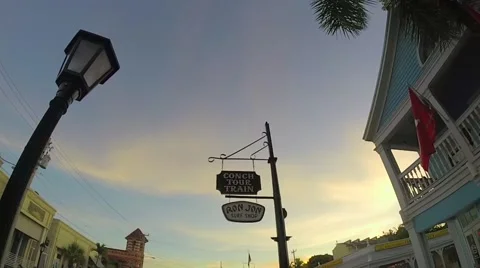 Ron jon surf shop and conch tour train signs at sunset in key west florida ke Stock Footage 41868986