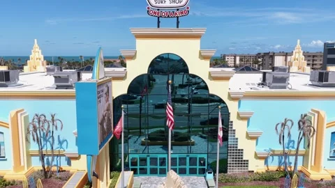 Ron Jon Surf Shop sign tops yellow Art Deco tower above arched glass entrance Stock Footage 340140705