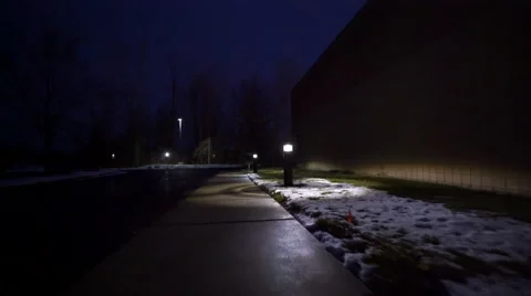 Ronin Stabilized shot moving down sidewalk at night turning towards light Stock Footage 59562956