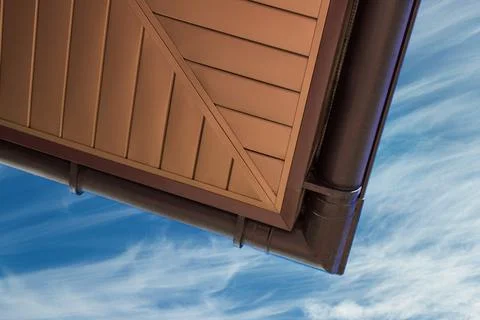 Roof cornice with gutter system against the blue sky Stock Photos