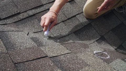 Roof hail damage inspection with chalk circles marking damaged shingles Stock Footage