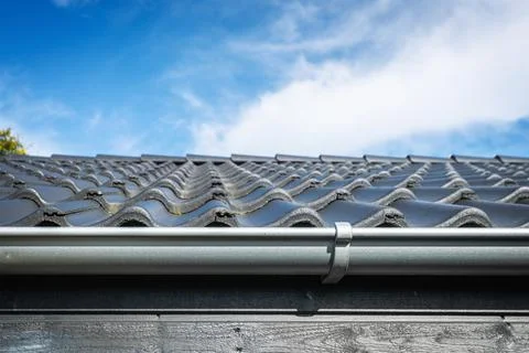 Roof on a house with tiles and a gutter Stock Photos