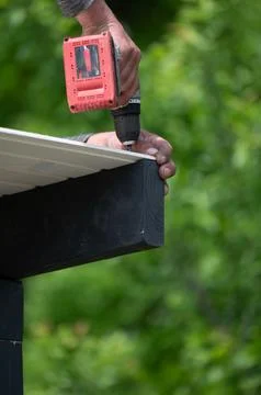 Roof installation steps using a screwdriver. Fotos de archivo