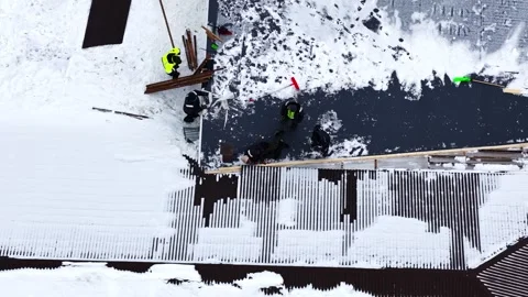 Roof maintenance during winter, workers clearing snow and performing repairs Stock Footage 340216816