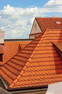Roof repair, worker with yellow gloves replacing red tiles or shingles on ho Stock Photos