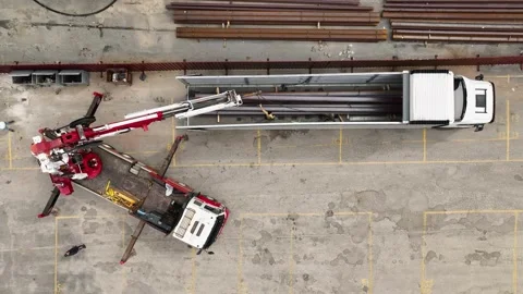 Roof Support in Action: Aerial View of Workers Loading Metal Beams for Roof Stock Footage 243203553
