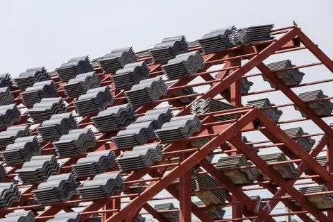 Roof under construction with stacks of roof tiles for home building Stock Photos