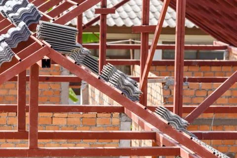 Roof under construction with stacks of roof tiles for home building Stock Photos
