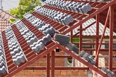 Roof under construction with stacks of roof tiles for home building Stock Photos