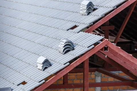 Roof under construction with stacks of roof tiles for home building Stock Photos