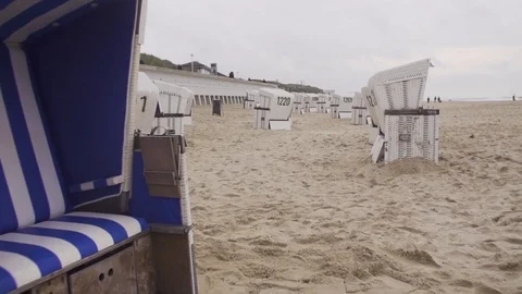 Roofed wicked beech chairs arranged on beach Stock Footage 71566231