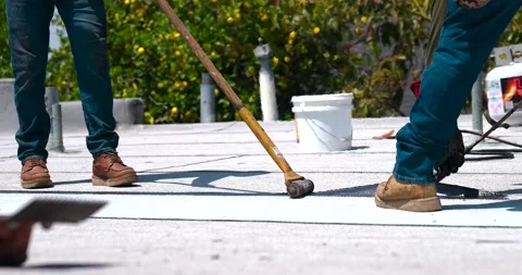 Roofer applying granulated APP Torch Down and Using a Roller Stock Footage 277974074