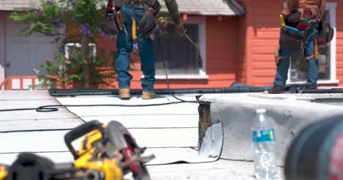 Roofer applying granulated APP Torch Down and Using a Roller Stock Footage 292160390