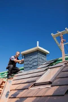 Roofer assembling tiles on a chimney Stock Photos