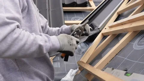 Roofer carpenter uting side cutters to cut a piece of metal Stock Footage 235787680