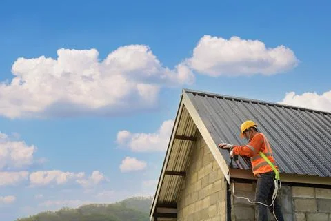 Roofer Construction worker install new roof,Roofing tools,Electric drill used Stock Photos