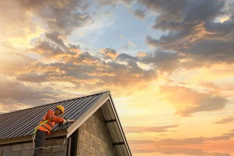 Roofer Construction worker install new roof,Roofing tools,Electric drill used Stock Photos