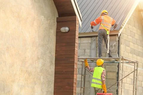 Roofer Construction worker install new roof,Roofing tools,Electric drill used Stock Photos