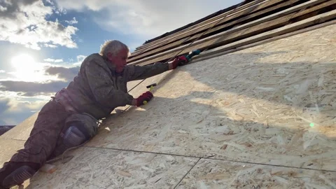 Roofer man on roof making repairs in Ukraine after war damage. Roof renovation Vídeo Stock 246505402