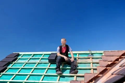 Roofer resting on top of a roof Stock Photos
