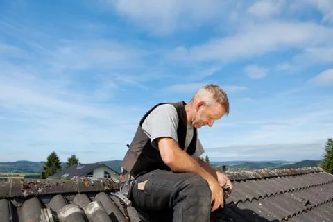 Roofer sitting on the rooftop 写真素材