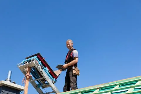 Roofer standing near a construction elevator Fotos de archivo