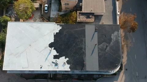 Roofer team lay black roofing material on white flat roof. Aerial texture Stock Footage 143976586