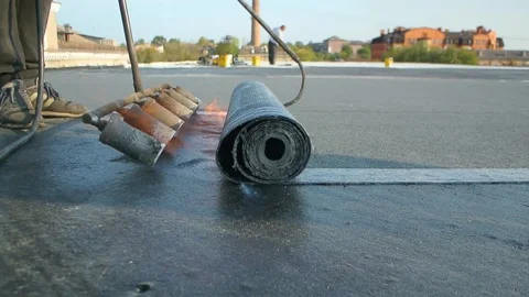 Roofer team lay black roofing material on white flat roof. Stock Footage 144941524