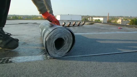 Roofer team lay black roofing material on white flat roof. Stock Footage 144941543