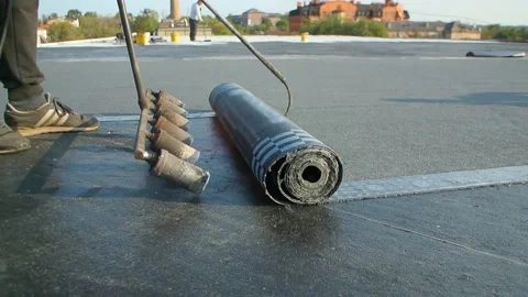 Roofer team lay black roofing material on white flat roof. Stock Footage 144941601