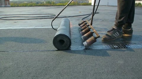 Roofer team lay black roofing material on white flat roof. Stock Footage 144941605