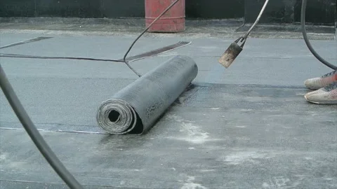 Roofer team lay black roofing material on flat roof Stock Footage 196810694