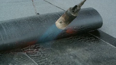 Roofer team lay black roofing material on flat roof Stock Footage 196811087