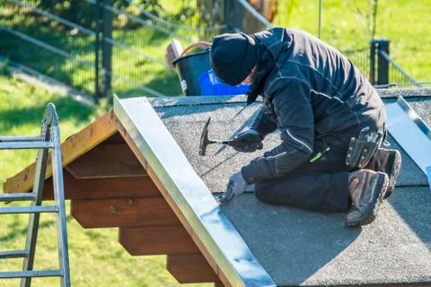 Roofer worker using hammer for maintenance Stock Photos