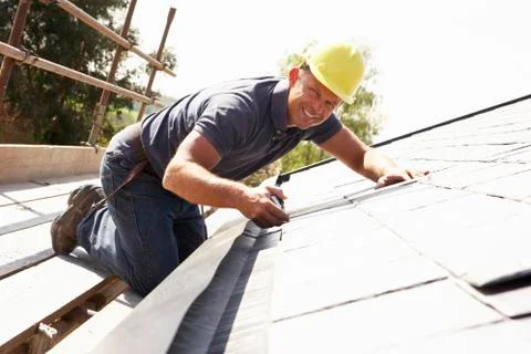 Roofer Working On Exterior Of New Home Stock Photos