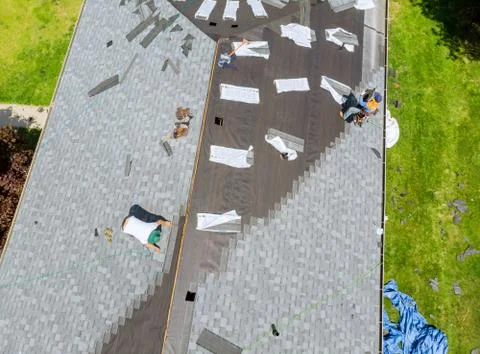 Roofer working on replacement asphalt shingle roof Stock Photos
