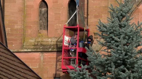 Roofers in man basket, maintenance work on gothic church facade, rural Germany Video stock 82739418