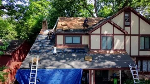 Roofers put a new roof on removing shingles and nailing new ones in place Stock Footage 342749853