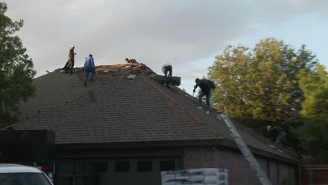 Roofers remove old shingles from an urban home, 4K. Stock Footage 140977863