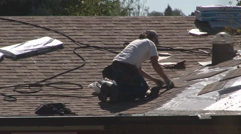 Roofing contractor carefully aligns shingles Stock Footage 942229
