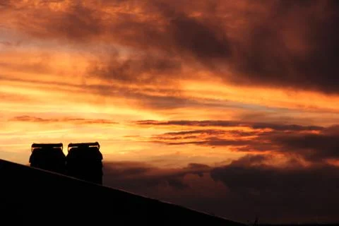 Roofs and chimneys at sunset with clouds and smog 写真素材