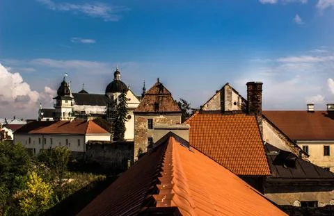 Roofs of a building through a window from another building against the sky. Stock Photos